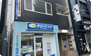 1階にポニークリーニングさんがあるビルの2階になります。オートロックなので201を押してください。